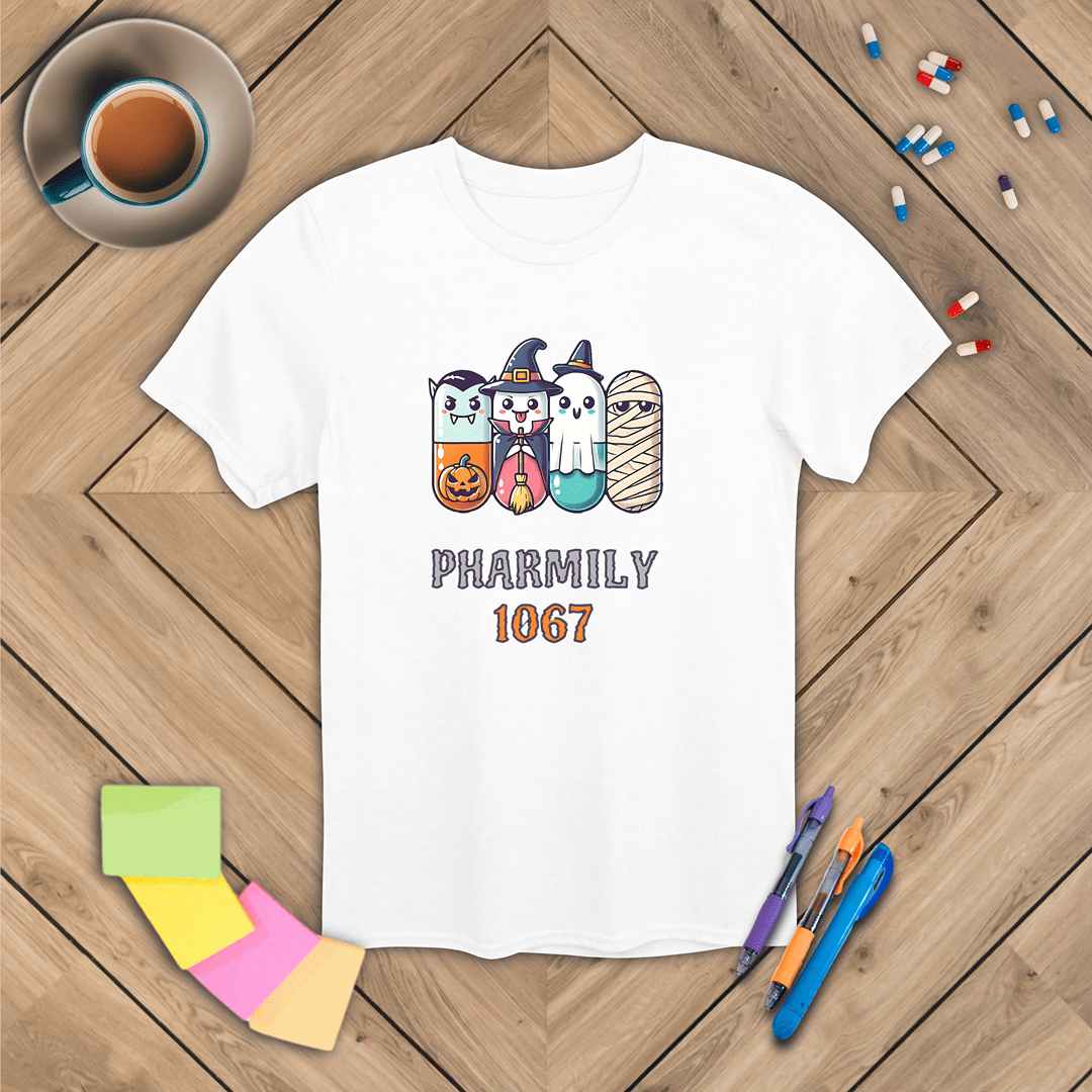 White t-shirt with Halloween-themed design on a wooden surface with stationery items.